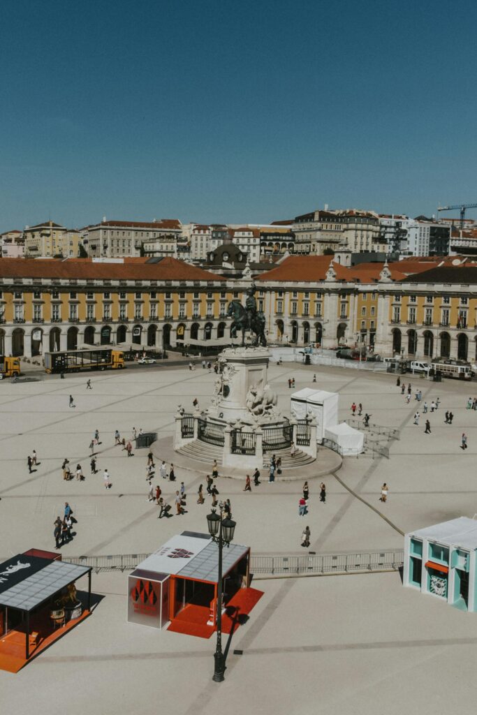 Aerial view of Praça do Comércio in Lisbon with its iconic statue and bustling square.